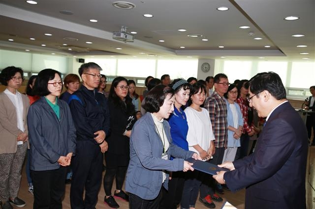 이동진 서울 도봉구청장이 지난해 10월 구 평생학습관 2층 소강의실에서 중장년층 대상 중국어교실 수강생들에게 수료장을 주고 있다.