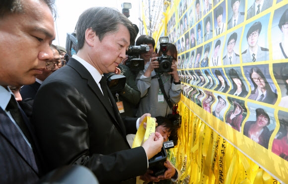 안철수 국민의당 대선 후보가 9일 전남 목포신항을 찾아 세월호 희생자를 추모하는 노란 리본을 철조망에 매달고 있다. 목포 연합뉴스