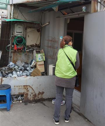 ‘찾아가는 이웃돌보미’가 고물상을 찾아 폐지 줍는 노인 등 지역 내 주거위기 가구를 조사하고 있다. 광진구 제공