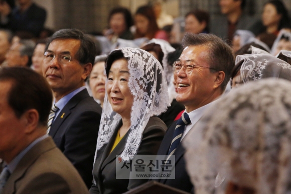 문재인 더불어민주당 대통령 후보와 심상정 정의당 대통령 후보가 16일 낮 서울 중구 명동성당에서 부활절 미사를 드리고 있다. 미사 중 음향사고로 큰 소리가 나자 염수경 추기경이 ”예수의 부활은 이처럼 놀라운 일이다”라고 말하자 두 후보가 웃고 있다.  이종원 선임기자.jongwon@seoul.co.kr