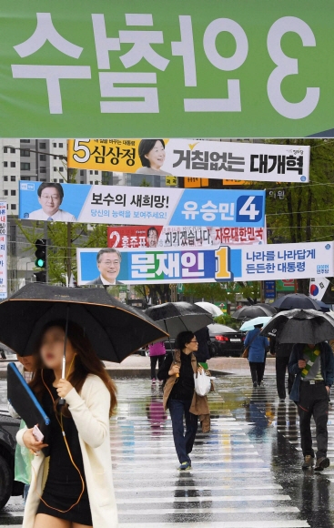대통령 선거 운동이 시작된 지 이틀째인 18일 시민들이 대선 후보들의 현수막이 걸려 있는 서울 서대문구 독립문사거리의 횡단보도를 건너고 있다. 이언탁 기자 utl@seoul.co.kr