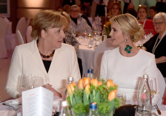 도널드 트럼프 미국 대통령의 장녀 이방카(오른쪽)가 25일(현지시간) 독일 베를린에서 열린 주요 20개국 여성경제정상회의(W20) 축하 만찬장에서 옆 좌석에 앉은 앙겔라 메르켈(왼쪽) 독일 총리와 대화를 나누고 있다. 베를린 AFP 연합뉴스