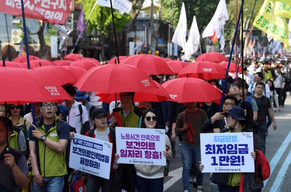 노동절인 1일 서울 종로구 대학로에서 열린 2017 세계 노동절 대회에서 참가자들이 손피켓과 빨간 우산을 들고 행진하고 있다.  박윤슬 기자 seul@seoul.co.kr