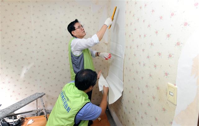 유 구청장이 어려운 이웃들의 집을 새 단장해 주는 도배봉사를 하고 있다. 동대문구 제공