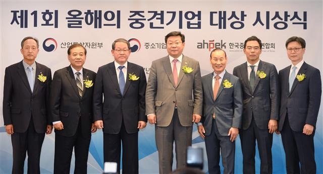 주형환 산업통상자원부 장관과 ‘올해의 중견기업 대상’ 수상자들이 8일 서울 중구 소공동 롯데호텔에서 기념 촬영을 하고 있다. 왼쪽부터 오경환 샘표식품 전무, 이인광 서연이화 상무, 강호갑 중견기업연합회 회장, 주 장관, 최병오 패션그룹 형지 회장, 김치환 삼기오토모티브 대표, 윤재훈 종근당 상무. 산업통상자원부 제공