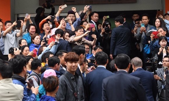 제19대 대통령에 당선된 문재인 더불어민주당 후보가 9일 오전 8시 30분쯤 서울 서대문구 홍은중학교에 마련된 투표소에 부인 김정숙 여사와 들어서자 시민들이 손을 뻗어 환호를 보내고 있다. 이언탁 기자 utl@seoul.co.kr