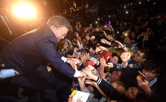 문재인 제19대 대통령이 지난 9일 밤 서울 광화문 세종로 소공원에서 열린 대국민 인사에서 단상에 올라 지지자들의 손을 잡고 있다. 정연호 기자 tpgod@seoul.co.kr