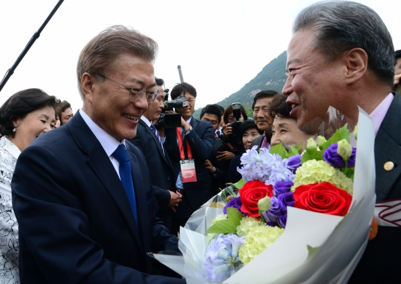 문재인 대통령이 10일 청와대 앞 분수대에서 청운효자동 주민대표로부터 축하 꽃다발을 받고 인사를 나누고 있다. 안주영 기자 jya@seoul.co.kr