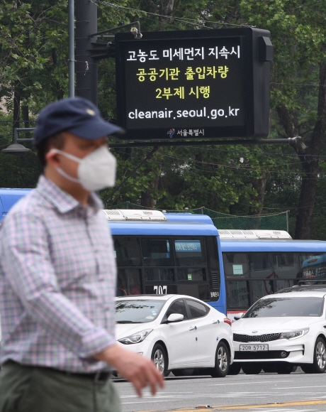 몽골과 중국동북부지방에서 발원한 황사가 찾아온 12일 마스크를 쓴 한 시민이 서울 중구 태평로에 설치된 대기오염 전광판 앞을 지나가고 있다.  손형준 기자 boltagoo@seoul.co.kr