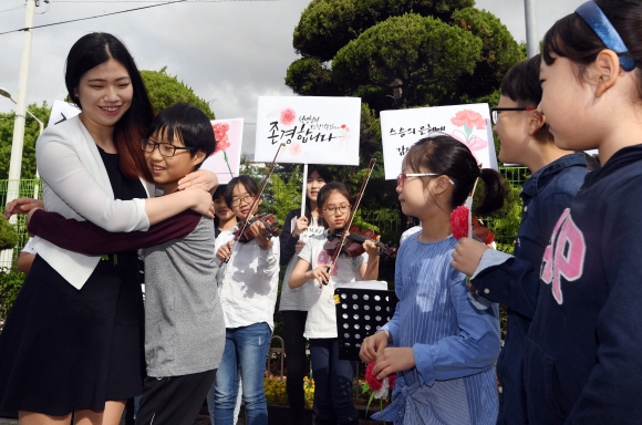 스승의 날인 15일 서울 송파구 풍성초등학교에서 학생들이 출근하는 선생님들에게 카네이션을 달아 주고 선생님과 포옹하고 있다. 2017. 5. 15. 박윤슬 기자 seul@seoul.co.kr