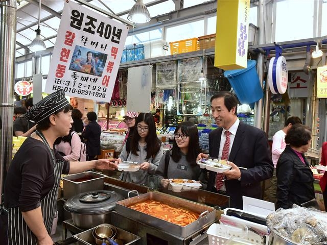 문 구청장이 지난해 10월 독립문 영천시장의 점심 도시락 뷔페 ‘고루고루’를 방문해 주민들과 떡볶이를 사 먹고 있다.  서대문구 제공