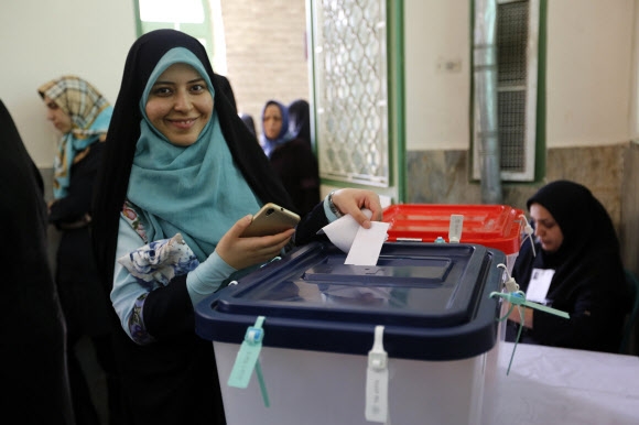 활짝 웃으며 투표하고 있는 이란 여성