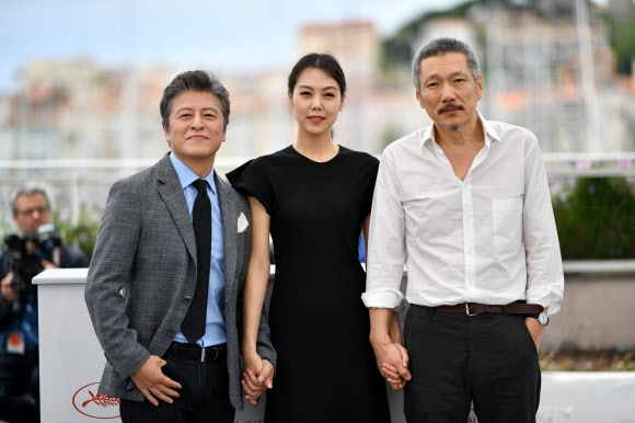 22일(현지시간) 프랑스 칸에서 열리고 있는 ‘제70회 칸국제영화제’ 경쟁부분에 초청된 홍상수 감독의 영화 ‘그 후(The Day After)’ 포토콜에서 홍상수 감독(오른쪽)과 배우 권해효, 김민희가 포즈를 취하고 있다. AFP 연합뉴스
