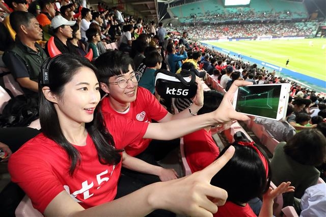 지난 23일 전주월드컵경기장에서 열린 한국-아르헨티나 예선경기에서 KT 모델이 스마트폰으로 5G 미디어 서비스를 시연하고 있다. KT 제공