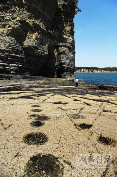 상족암 주변 풍경. 바닥면의 공룡 발자국 화석과 상다리를 닮은 거대한 해식애가 멋진 풍경을 펼쳐 내고 있다.