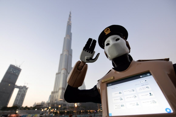로보캅 현실로?… 세계 첫 로봇 경찰 세계 최초 인공지능 로봇 경찰관이 31일(현지시간) 아랍에미리트 두바이에 등장해 거수경례를 하고 있다. 이 로봇은 사람의 감정과 표정을 인식할 수 있어 범죄자를 찾는 데 기여할 수 있고 신고도 받을 수 있다. 두바이 AFP 연합뉴스