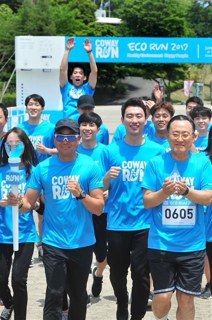 5일 경기 과천 서울대공원에서 열린 ‘코웨이런’에서 이봉주(앞줄 왼쪽) 전 국가대표 마라톤 선수와 이해선(오른쪽) 코웨이 대표이사가 참가자들과 함께 ‘소중한 물 안고 달리기’ 행사에 참여하고 있다. 코웨이 제공