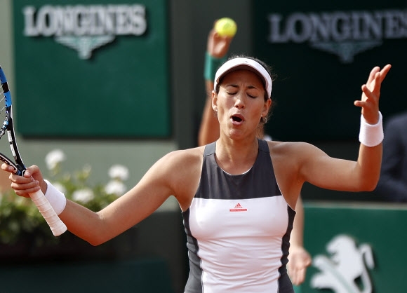 디펜딩 챔피언이자 세계랭킹 5위의 가르비네 무구루사(스페인)가 5일 크리스티나 믈라데노비치(프랑스)와의 프랑스오픈 테니스 4회전에서 1-2로 져 16강에서 탈락하자 팔을 들어 낙담한 표정을 짓고 있다. 파리 AP 연합뉴스