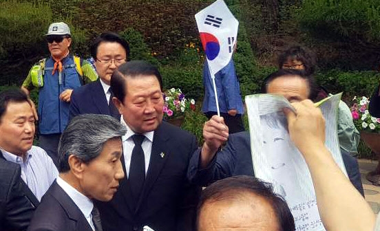 현충일인 6일 오전 태극기와 성조기를 든 보수단체 회원들이 김대중 전 대통령 묘역을 참배하던 국민의당 박주선 비상대책위원장을 둘러싸고 ’탄핵무효’ 등의 구호를 외치며 항의하고 있다.  독자 제공=연합뉴스