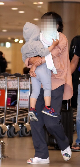 정유라씨 아들과 보모가 7일 오후 인천국제공항으로 입국, 보호를 받으며 공항을 빠져나가고 있다. 연합뉴스
