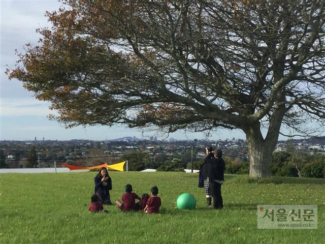 뉴질랜드 오클랜드의 켈스턴 청각장애학교 앞 잔디마당에서 교사와 청각장애 어린이들이 야외수업을 하고 있다. 뉴질랜드에는 28개의 특수학교가 있으며. 정규학교와 똑같은 교육과정으로 운영돼 학력 격차가 발생하지 않는다.