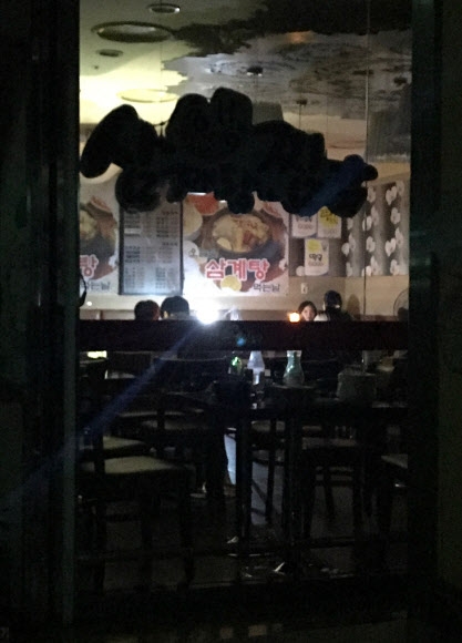 서울 서남부 일대와 경기 광명 등에 대규모 정전이 발생한 11일 오후 비상등을 제외한 모든 전등이 꺼진 구로구 신도림 테크노마트의 한 음식점에서 시민들이 식사하고 있다. 연합뉴스