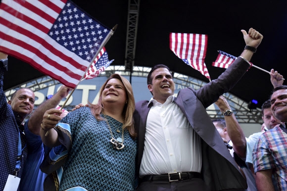 11일(현지시간) 실시된 푸에르토리코의 국가정체성 투표에 대한 출구조사 결과 미국의 주 지위 획득 안에 대한 찬성이 압도적으로 우세한 것으로 나오자 페드로 로셀로(오른쪽) 주지사가 미국 국기를 흔들며 혼호하고 있다. AP연합뉴스