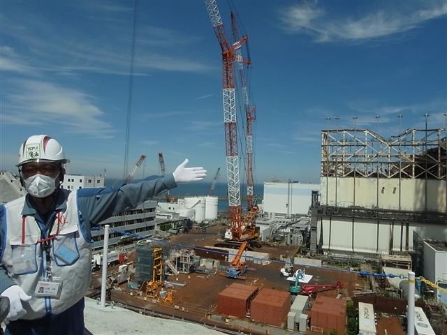 일본 도쿄전력 관계자가 지난 9일 후쿠시마 제1원자력발전소 부지에서 무너져 내린 시설물 복구 현장을 손으로 가리키며 2011년 3월 동일본대지진 당시 참상에 대해 설명하고 있다. 후쿠시마 공동취재단 연합뉴스