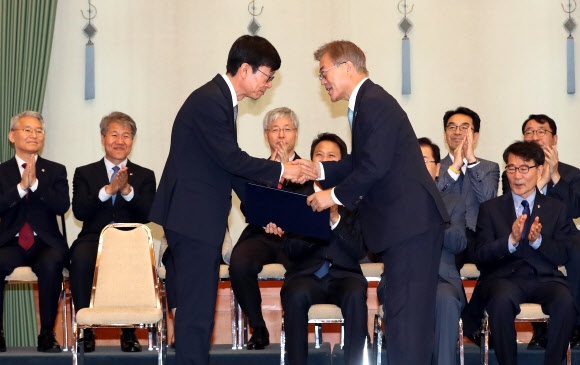 문재인 대통령(오른쪽)이 13일 오후 청와대에서 김상조 공정거래위원장에게 임명장을 수여하고 있다.  연합뉴스