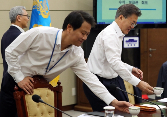 문재인 대통령이 15일 청와대에서 수석 보좌관회의를 주재했다. 문 대통령이 커피를 받아 자리로 돌아오고 있다.  안주영 기자 jya@seoul.co.kr