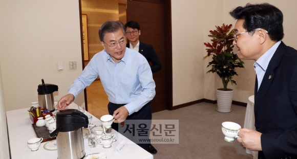 문재인 대통령이 22일 오전 청와대에서 열린 수석 보좌관회의에서 직접 커피를 들고 자리로 향하고 있다. 안주영 기자 jya@seoul.co.kr