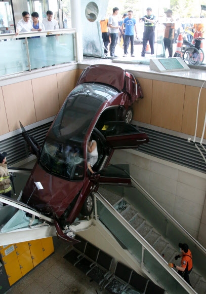 22일 오후 경기도 고양시 일산백병원 주차장을 나오던 그랜저 차량이 병원 건물로 돌진해 계단 아래로 추락해 있다. 연합뉴스