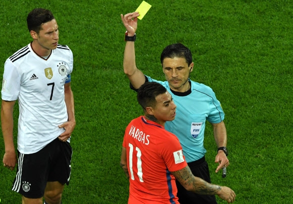   칠레 대표팀의 에두아르도 바르가스(등번호 11번)가 3일 러시아 상트페테르부르크 스타디움에서 열린 독일과의 국제축구연맹(FIFA) 컨페더레이션스컵 결승 도중 왼쪽의 제바스티안 루디가 파울을 저질렀다며 비디오판독(VAR)을 요청했다가 밀로라드 마지치 주심으로부터 옐로 카드를 받자 어이없어 하고 있다. 하지만 이번 대회 시범 도입을 결정한 FIFA는 선수나 벤치가 VAR을 요청하면 카드를 발급하도록 했다. 상트페테르부르크 AFP 연합뉴스 