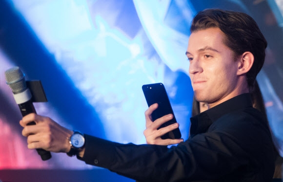 ‘3대 스파이더맨’ 톰 홀랜드가 3일 서울 여의도 콘래드호텔에서 열린 ‘스파이더맨:홈커밍’ 기자회견 도중 스마트폰을 들어 마이크와 취재진이 나오도록 내한 인증샷을 찍고 있다. 홀랜드는 ‘아이언맨’ 로버트 다우니 주니어와 함께 연기한 것에 대해 “꿈이 현실이 됐다”며 즐거워했다. 연합뉴스