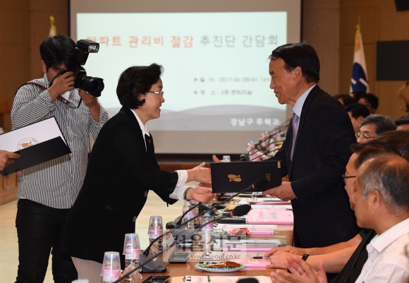 올해를 아파트 관리비 절감 원년으로 선언한 신연희(왼쪽) 강남구청장이 지난달 28일 구청에서 열린 아파트 관리비 절감 100인 추진단과의 첫 간담회에서 외부 전문가에게 위촉장을 주고 있다. 손형준 기자 boltagoo@seoul.co.kr