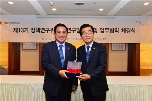 최영수 서울시의회 정책연구위원장(오른쪽)이 5일 양준욱 서울시의회 의장(왼쪽)과 함께 정책연구위원회 업무협약 체결식을 갖고 있다.