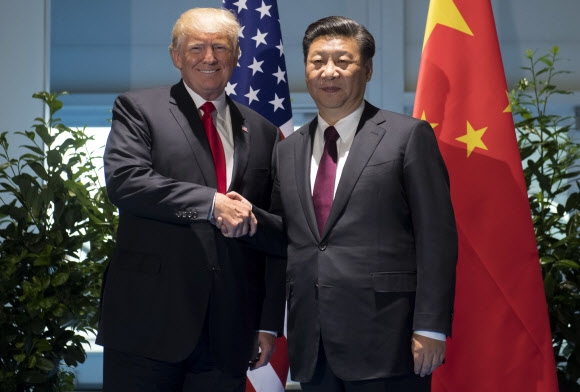 사진은 도널드 트럼프(왼쪽) 미국 대통령과 시진핑 중국 국가주석이 지난달 8일(현지시간) 독일 함부르크에서 열린 G20 정상회의에서 별도 회동하기에 앞서 악수를 하고 있는 모습. 함부르크 AP 연합뉴스