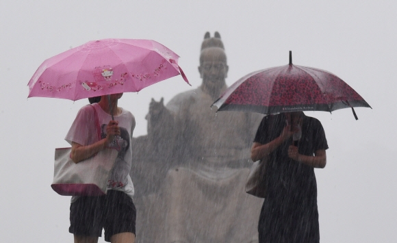 장맛비가 내린 10일 오후 거센 빗줄기 쏟아지는 서울 광화문광장에서 시민들이 우산을 쓴 채 걸어가고 있다. 2017. 7. 10 손형준 기자 boltagoo@seoul.co.kr