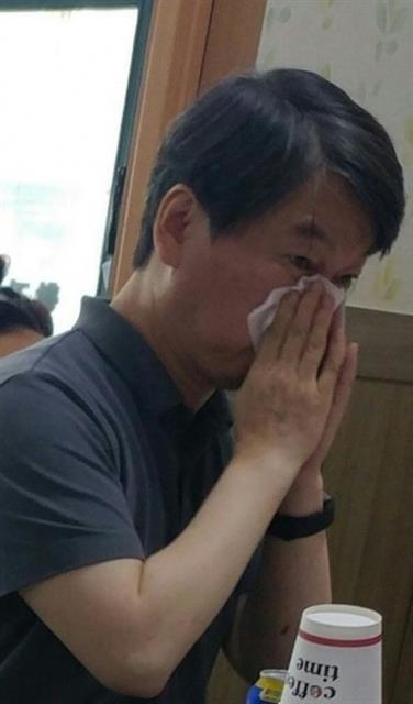 한 네티즌이 온라인 커뮤니티 사이트에 공개한 국민의당 안철수 전 대표가 강원 속초시의 한 식당에서 식사 중 휴지로 코를 푸는 듯한 모습.