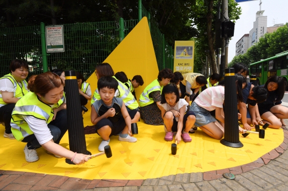 학부모, 어린이, 국제아동인권센터 등 봉사단체 회원들이 서울 강서초등학교 앞에서 최근 급증하는 스쿨존 교통사고를 줄이고자 옐로카펫을 설치하고 있다. 자라나는 꿈나무들의 안전을 위해서는 운전자들의 각별한 주의가 필요하다. 도준석 기자 pado@seoul.co.kr