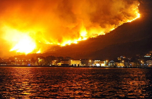 18일(현지시간) 크로아티아 스플리트 인근에서 대형 산불이 발생, 마을 뒤로 불길이 치솟고 있다.  AFP 연합뉴스