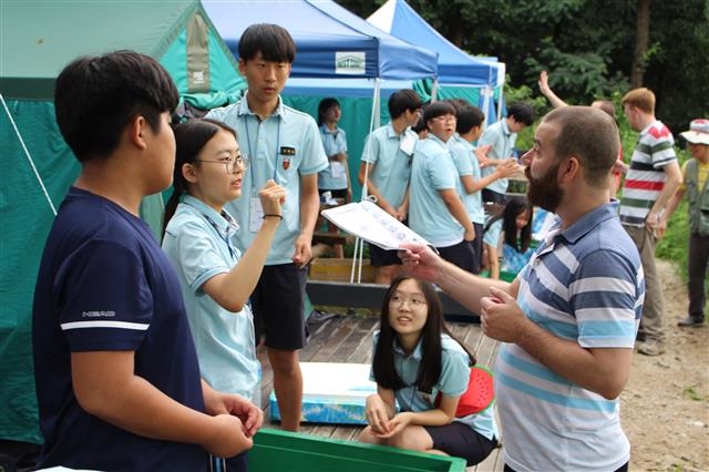 학생들이 서울 강동구 일자산에 위치한 강동그린웨이 가족캠핑장에서 열린 외국인 체험 캠핑에 참여해 외국인 선생님과 함께 즐거운 시간을 보내고 있다. 강동구 제공