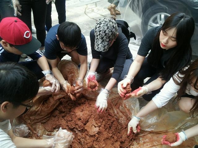 지난 5월 20일 ‘EM 흙공 만들기 체험 행사’에 참가한 학생들이 EM 효소발효액과 황토 등을 반죽해 EM 흙공을 만들고 있다. 광진구 제공
