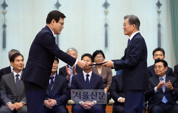 문재인 대통령이 21일 청와대에서 최종구 금융위원장에게 임명장을 수여하고 있다.  안주영 기자 jya@seoul.co.kr