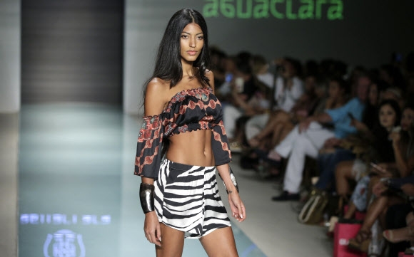 모델이 22일(현지시간) 미국 플로리다주 마이애미비치에서 열린 스윔 위크 중 FUNKSHION 패션쇼에서 Agua Clara 수영복을 입고 런웨이를 걷고 있다. AP 연합뉴스