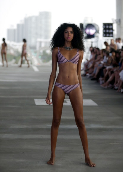 모델이 22일(현지시간) 미국 플로리다주 마이애미비치 주차장에서 열린 스윔 위크 중 FUNKSHION 패션쇼에서 Acacia 수영복을 입고 런웨이를 걷고 있다. AP 연합뉴스
