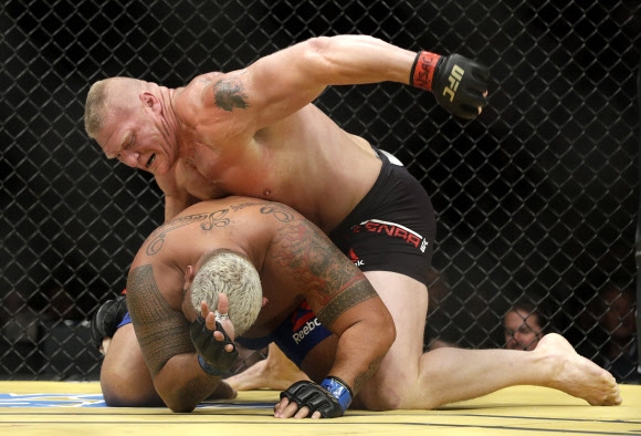브록 레스너(위)가 지난해 7월 9일(현지시간) UFC 200 마크 헌트와의 대결 때 파운딩 공격을 시도하고 있다. AP 자료사진 연합뉴스 
