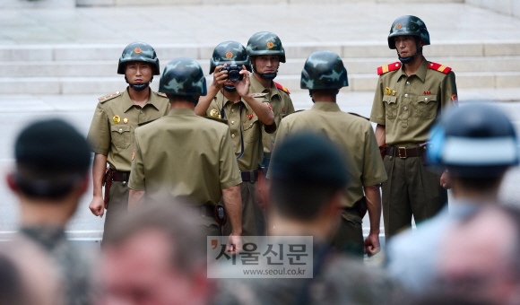 정전협정 64주년인 27일 판문점에서 북한 병사들이 정전기념행사에 참석해 기념사진을 찍는 참전국 대표단을 배경으로 기념사진을 찍고 있다.  사진공동취재단