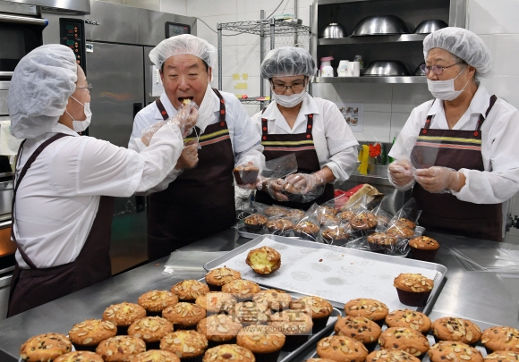 홍섭(왼쪽 두 번째) 서울 마포구청장이 27일 어르신을 위한 시장(수익)형 일자리 사업으로 운영 중인 염리동 ‘리위쿠키’에서 직원들이 건네준 머핀을 맛보고 있다. 강성남 선임기자 snk@seoul.co.kr