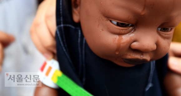 28일 서울 청계천에 설치된 국경없는의사회 구호텐트에서 단체소속 활동가가 기아아동의 상태를 점검하는 시연을 펼치는 가운데 아기인형의 눈에서 눈물이 떨어지고 있다. 박지환 기자 popocar@seoul.co.kr